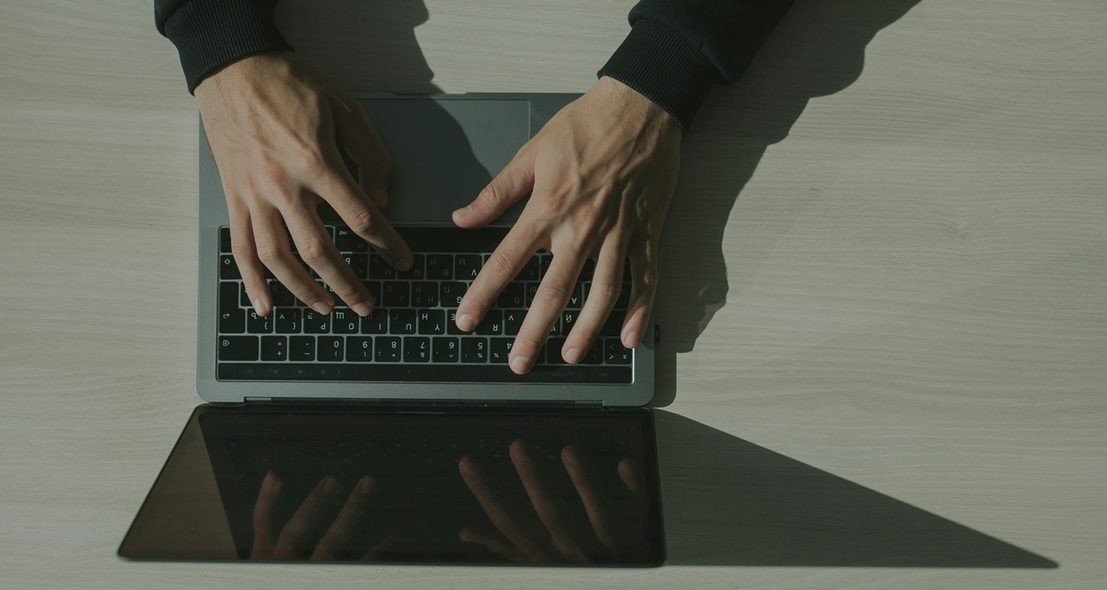 Hands typing on a laptop
